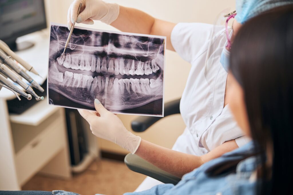 A forensic dentist in New Bern discusses an x-ray with a client.