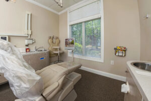 One of the dentist's chairs facing a window at Evolve's offices for a dentist in Craven County.
