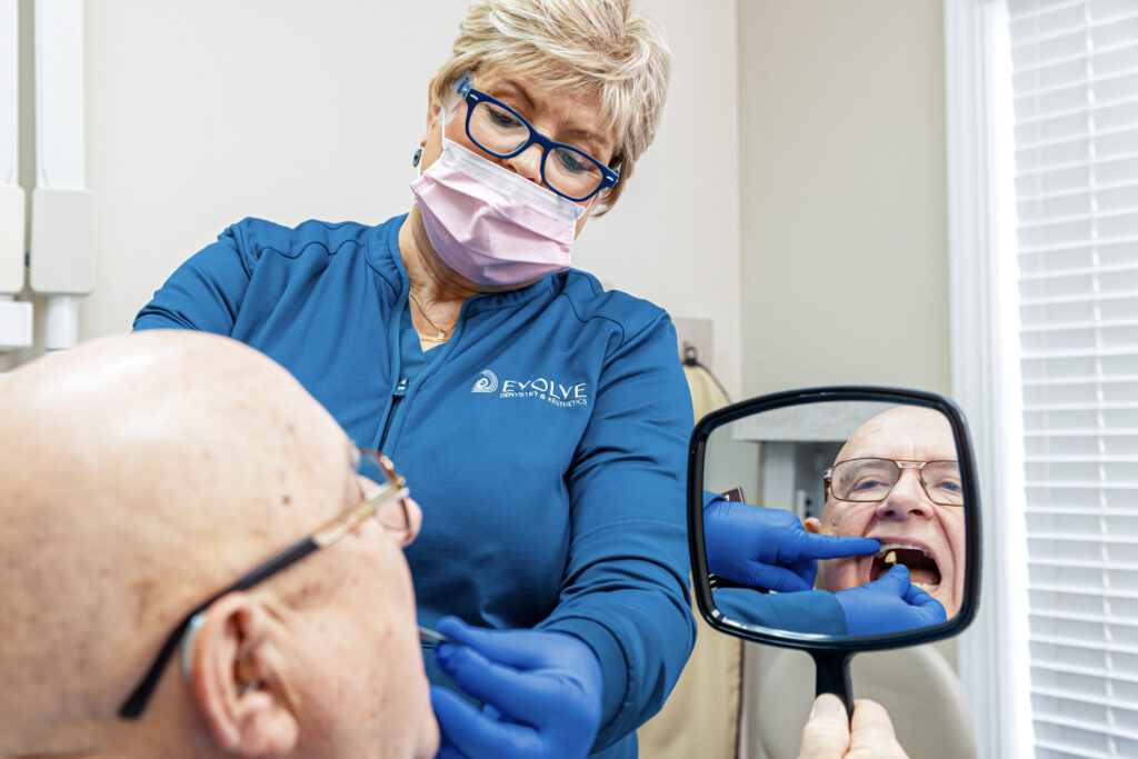 A restorative dentist near Trent Woods talks to a patient about a crown.