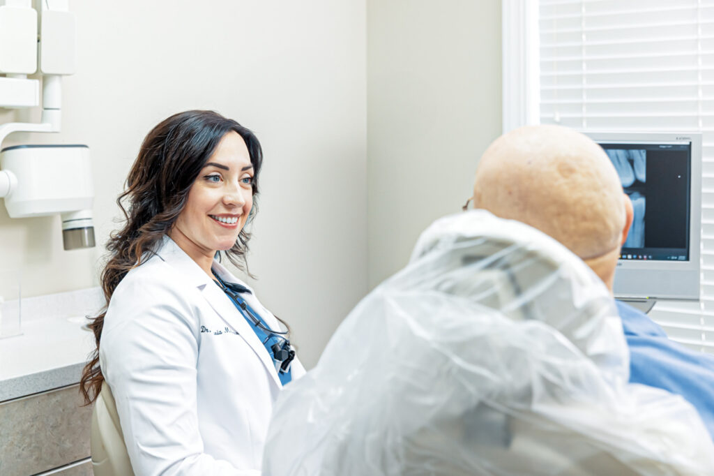 Dr. McGowen smiles with a patient as they discuss teeth cleaning in Craven County.
